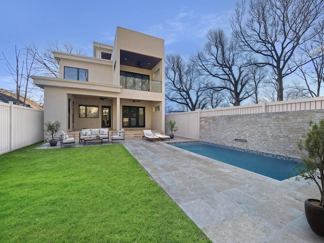 back of house with a patio, a balcony, an outdoor hangout area, ceiling fan, and a fenced in pool