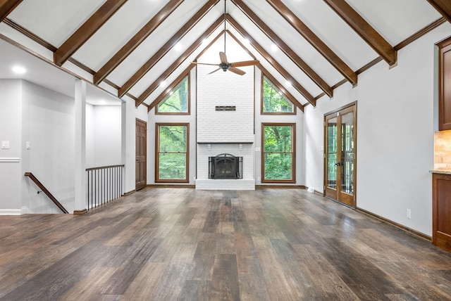 unfurnished living room with a brick fireplace, dark wood-type flooring, high vaulted ceiling, and a healthy amount of sunlight