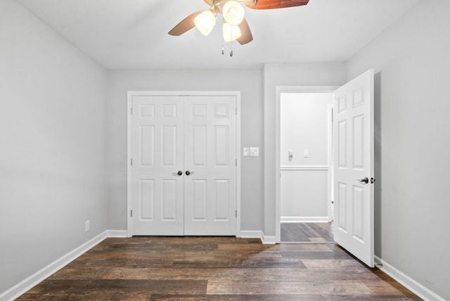 unfurnished bedroom featuring ceiling fan, dark hardwood / wood-style flooring, and a closet