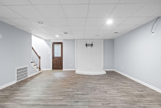 interior space featuring a drop ceiling and light hardwood / wood-style flooring