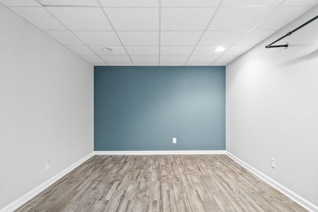 spare room featuring light hardwood / wood-style floors and a drop ceiling