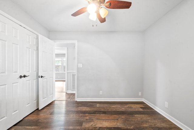 empty room with dark wood-type flooring and ceiling fan