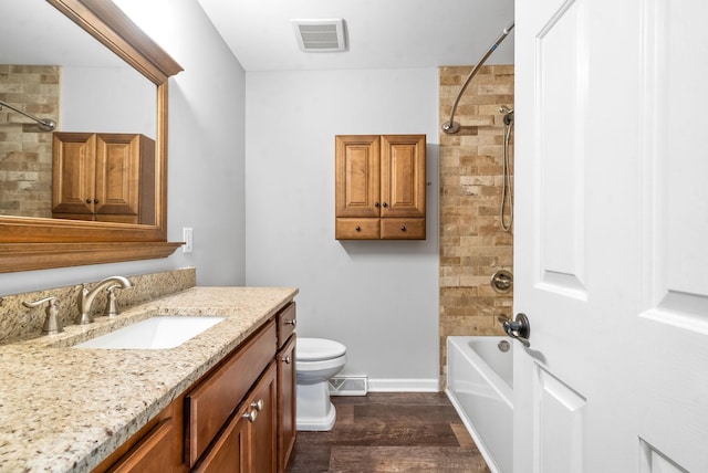 full bathroom with tiled shower / bath combo, vanity, wood-type flooring, and toilet