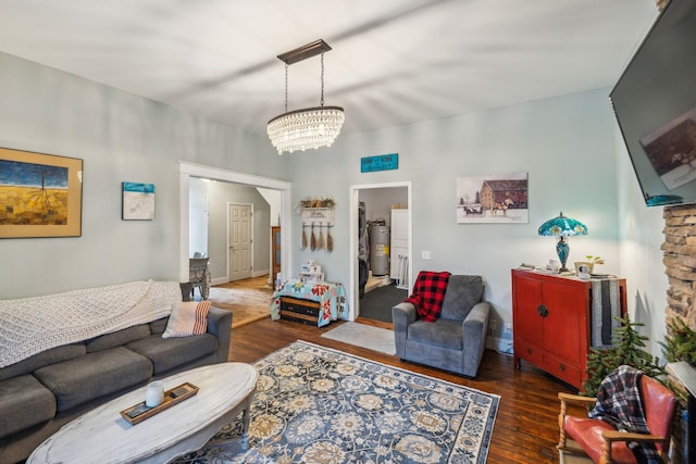 living room with dark hardwood / wood-style floors, electric water heater, and a notable chandelier