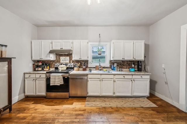 kitchen with sink, light hardwood / wood-style flooring, appliances with stainless steel finishes, white cabinetry, and backsplash