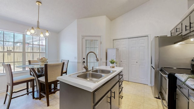 kitchen featuring decorative light fixtures, lofted ceiling, a sink, an island with sink, and stainless steel range with electric stovetop