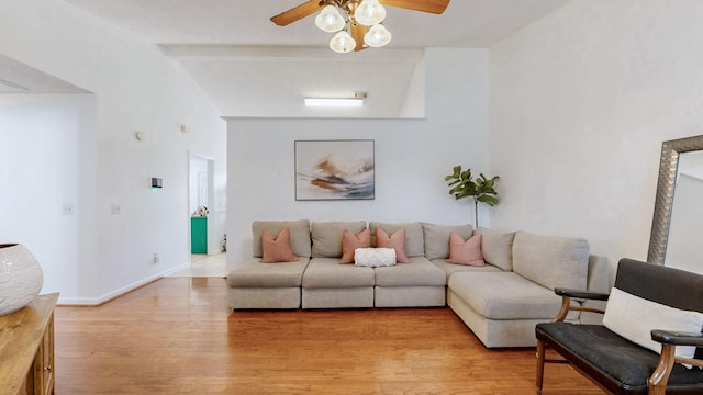 living area with vaulted ceiling with beams, light wood-style flooring, baseboards, and ceiling fan