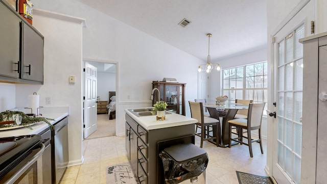 kitchen with visible vents, a sink, a notable chandelier, vaulted ceiling, and stainless steel dishwasher