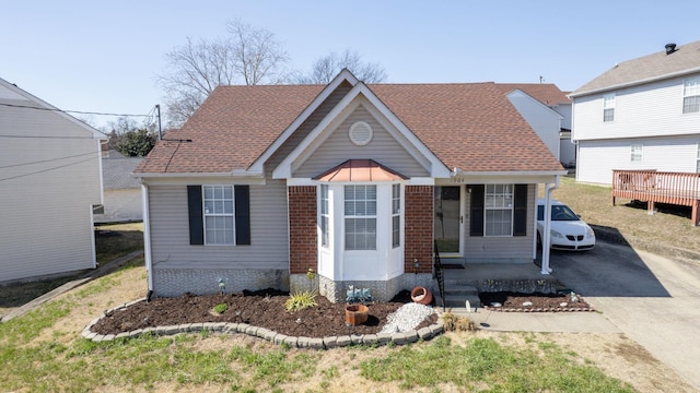 view of front of property with driveway, a shingled roof, and brick siding