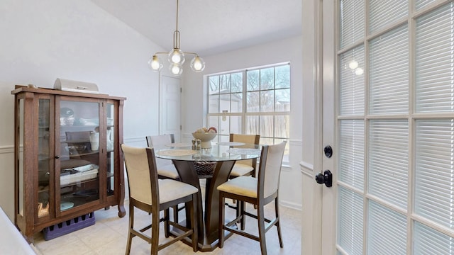 dining space with vaulted ceiling and an inviting chandelier