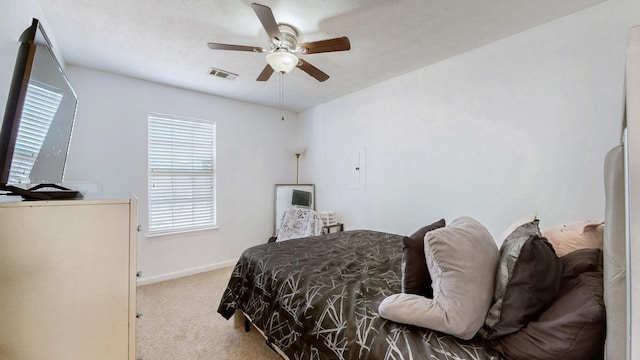 carpeted bedroom featuring baseboards, visible vents, and ceiling fan