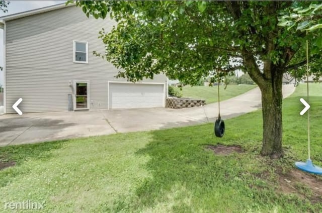 view of property exterior with a garage and a yard