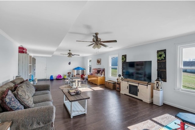 living area with a wealth of natural light, baseboards, and wood finished floors