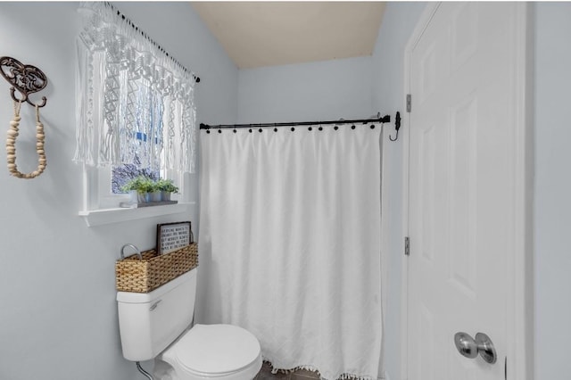 bathroom with a shower with curtain and toilet