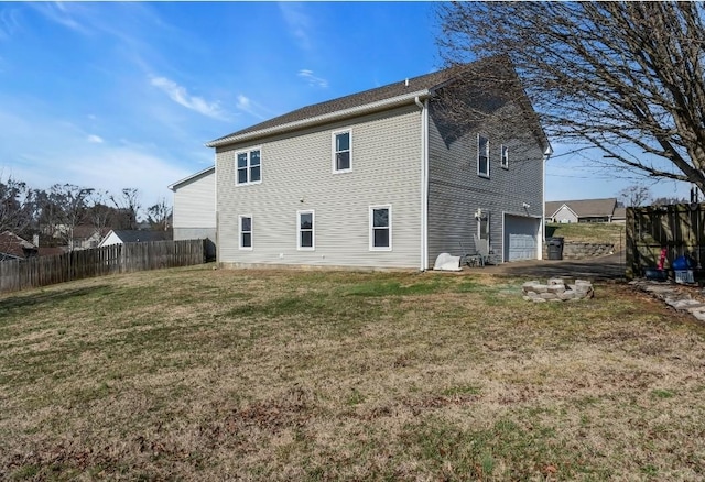 back of house with a lawn, a garage, and fence