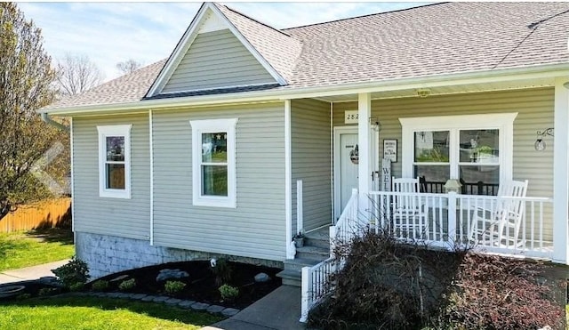 view of front of property featuring roof with shingles and covered porch