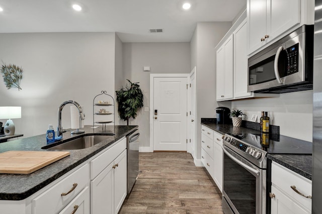 kitchen with white cabinetry, sink, an island with sink, and appliances with stainless steel finishes