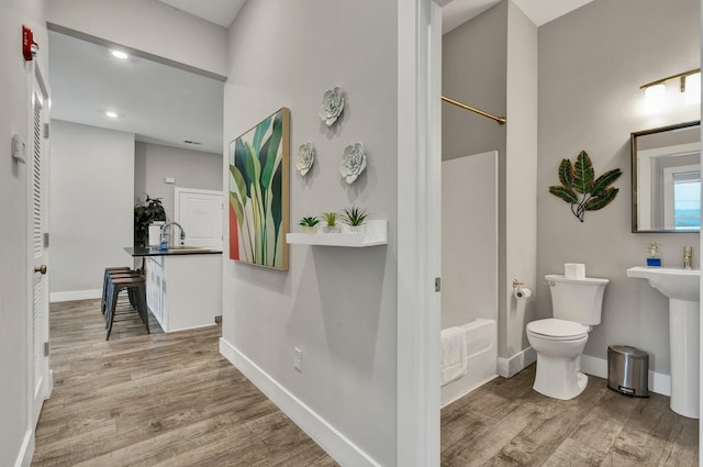 full bathroom with wood-type flooring, toilet, sink, and shower / bathing tub combination