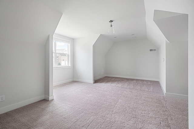 bonus room featuring lofted ceiling and light colored carpet