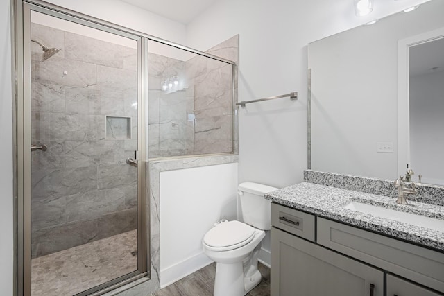 bathroom featuring vanity, toilet, a shower with door, and hardwood / wood-style floors