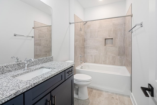 full bathroom featuring tiled shower / bath, vanity, and toilet