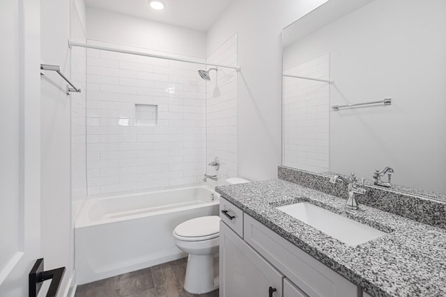 full bathroom with vanity, tiled shower / bath combo, wood-type flooring, and toilet