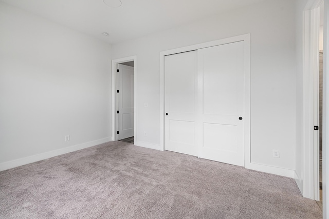 unfurnished bedroom featuring a closet and carpet flooring