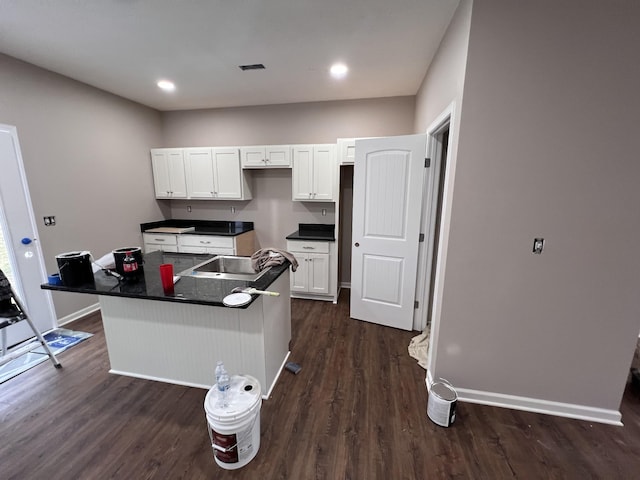 kitchen with white cabinetry, dark hardwood / wood-style floors, and a center island