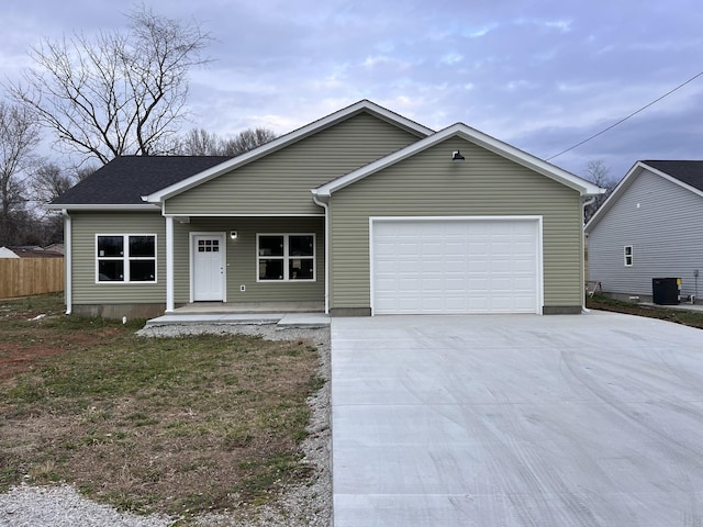 ranch-style home with a garage, central AC unit, and covered porch