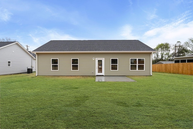 back of house with a patio area, fence, a shingled roof, a lawn, and central AC