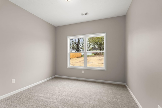 unfurnished room with carpet, baseboards, and visible vents