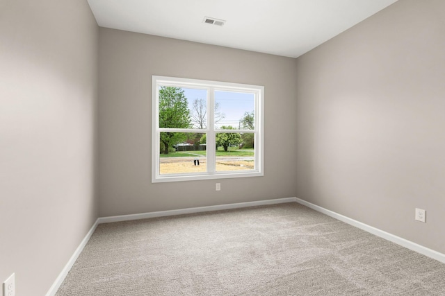 spare room featuring baseboards, visible vents, and carpet floors