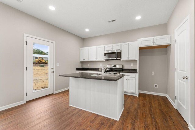kitchen with a sink, white cabinetry, visible vents, and stainless steel appliances