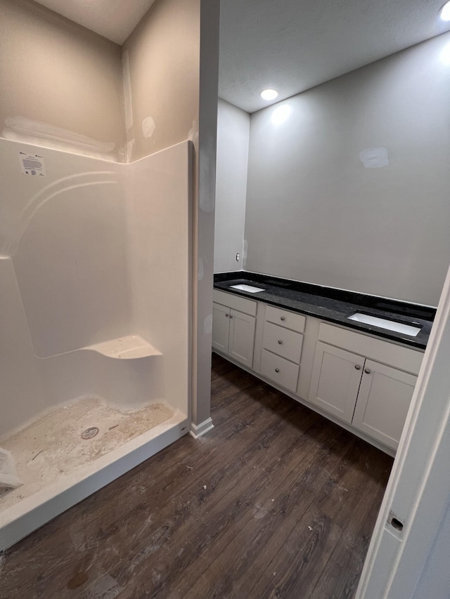 bathroom featuring vanity, hardwood / wood-style floors, and a shower