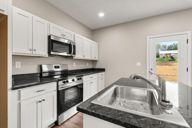 805 Shepard St S, Winchester, TN 37398 - kitchen with white cabinets, wood finished floors, a sink, and stainless steel appliances