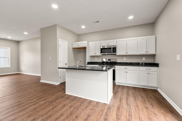 805 Shepard St S, Winchester, TN 37398 - kitchen with baseboards, white cabinetry, wood finished floors, and stainless steel appliances