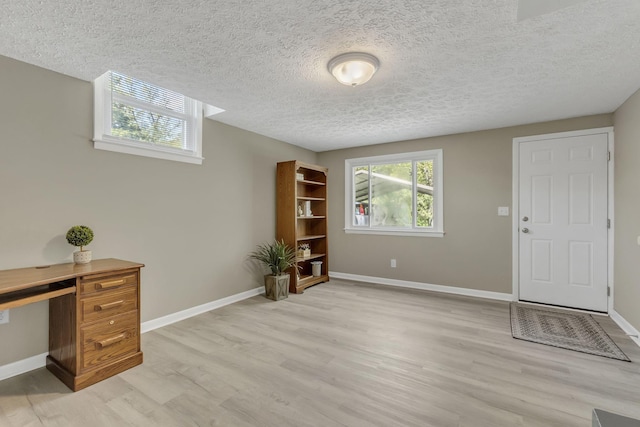 office with a textured ceiling and light hardwood / wood-style floors