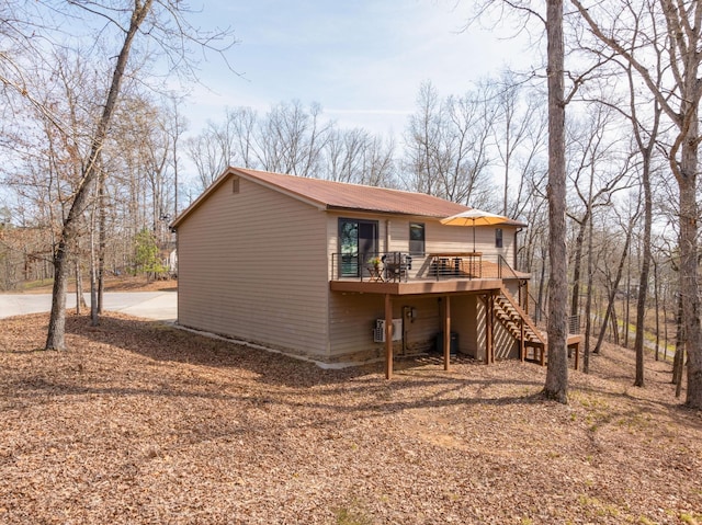 rear view of property with a wooden deck and central AC unit