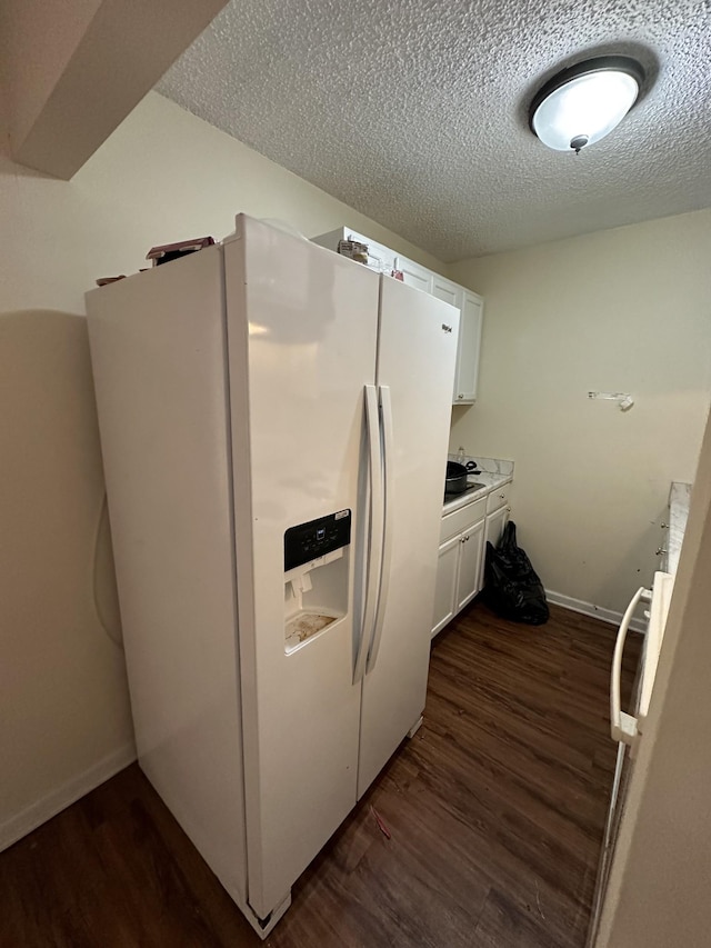 kitchen with white cabinetry, white fridge with ice dispenser, a textured ceiling, and dark hardwood / wood-style flooring