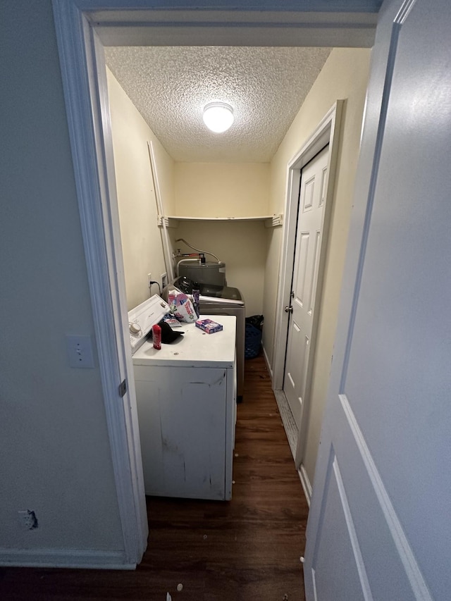 clothes washing area with independent washer and dryer, dark hardwood / wood-style floors, and a textured ceiling