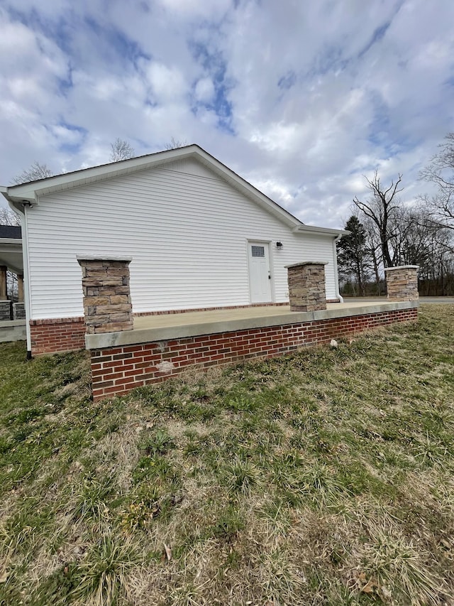 view of side of home with a lawn