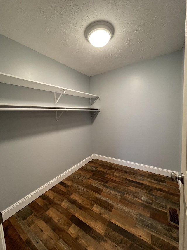 walk in closet featuring dark wood-type flooring