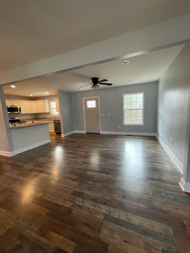 unfurnished living room with ceiling fan and dark hardwood / wood-style flooring