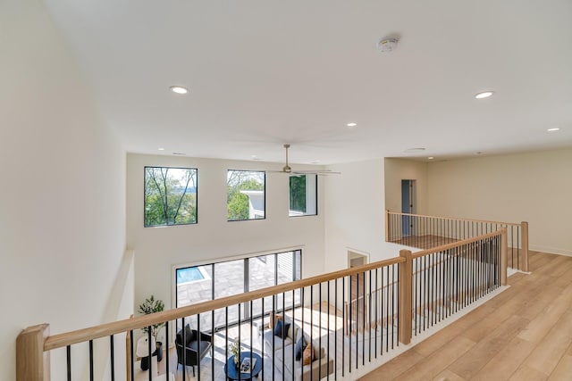 corridor with light hardwood / wood-style floors and a high ceiling