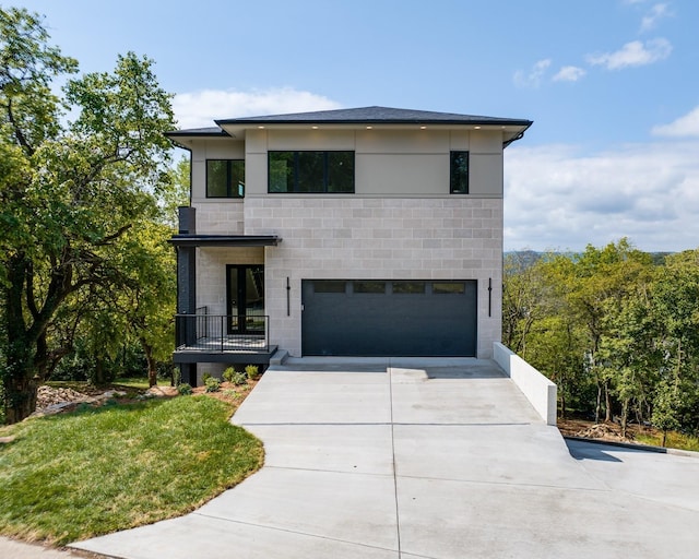 contemporary house featuring a garage and a front lawn