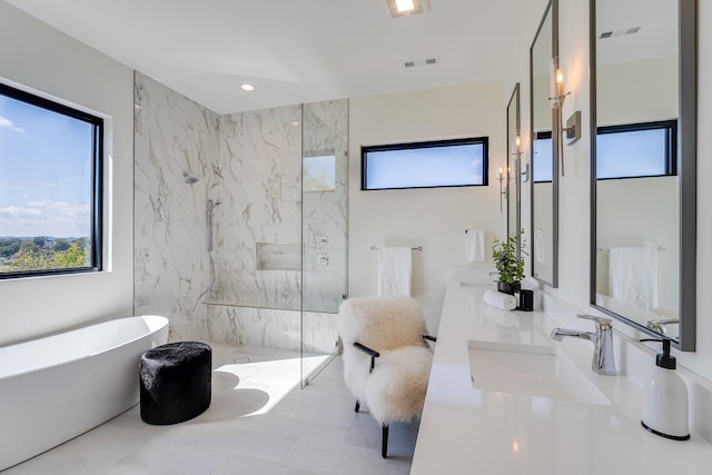 bathroom with vanity and shower with separate bathtub