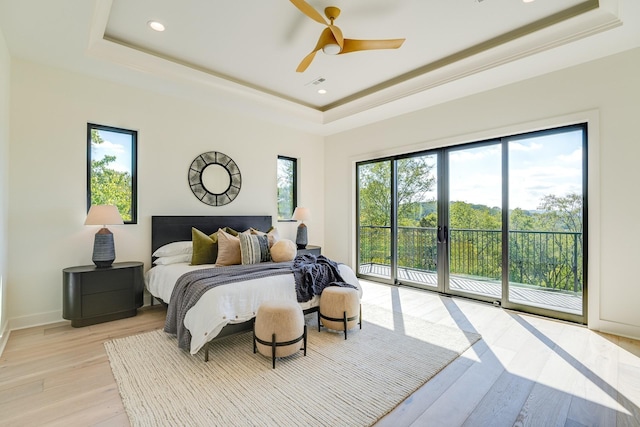 bedroom with access to outside, ceiling fan, a raised ceiling, crown molding, and light hardwood / wood-style flooring