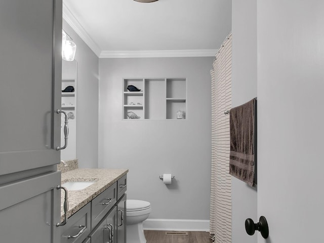 bathroom with vanity, hardwood / wood-style flooring, ornamental molding, and toilet