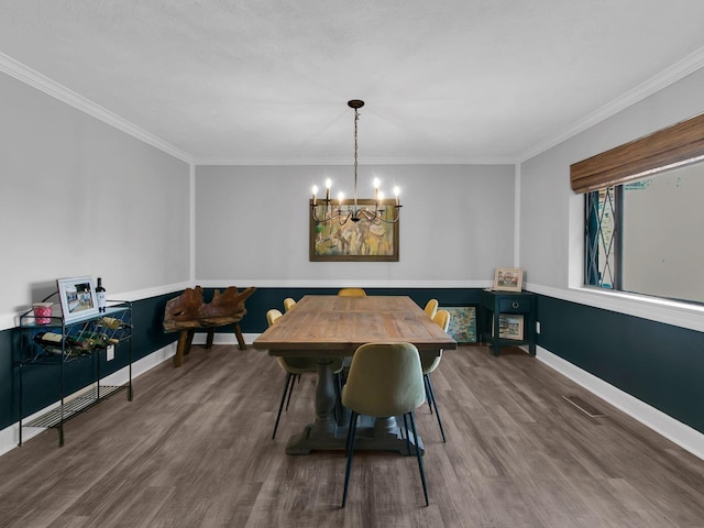 dining space with an inviting chandelier, wood-type flooring, and crown molding