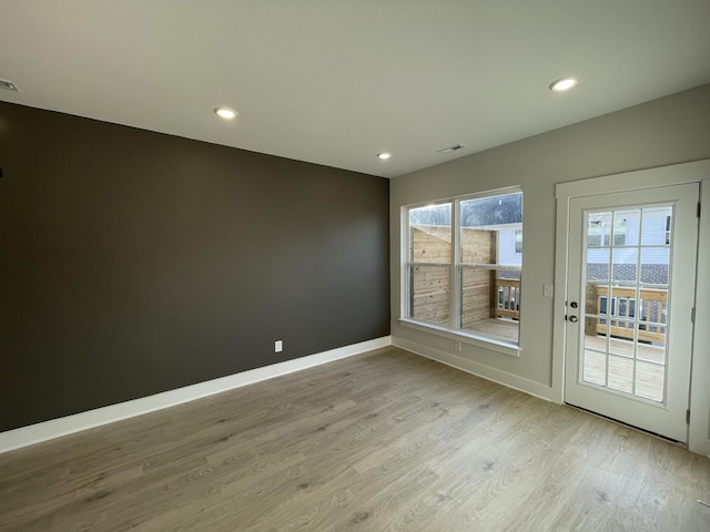 unfurnished room featuring a wealth of natural light and light wood-type flooring